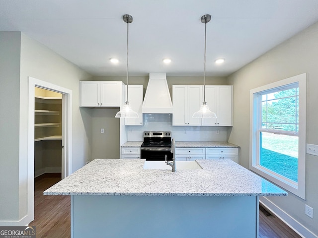 kitchen with dark wood-style flooring, electric range, white cabinetry, a sink, and premium range hood