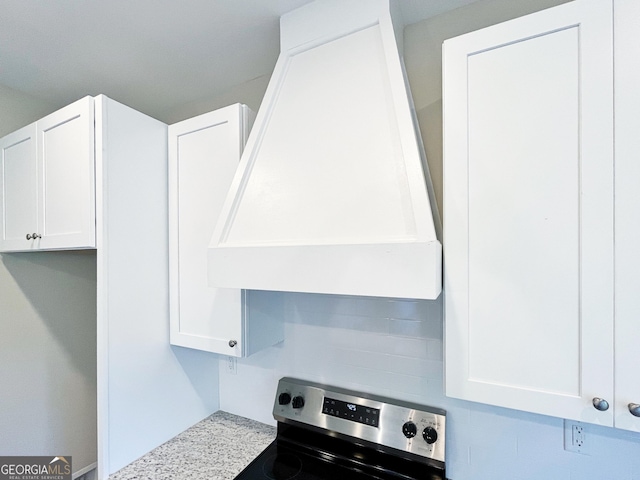 interior details with premium range hood, white cabinets, light countertops, and electric range