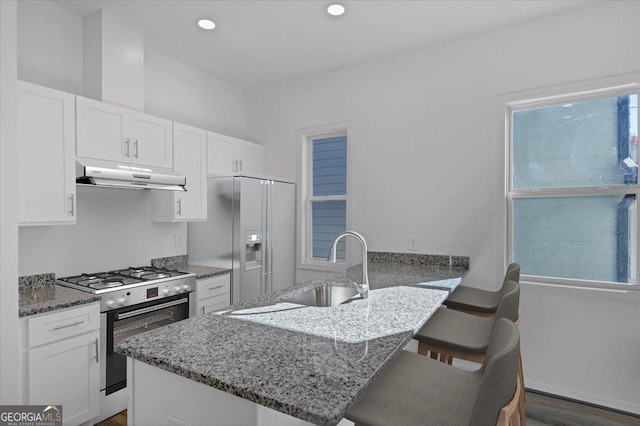 kitchen featuring white cabinetry, kitchen peninsula, stainless steel fridge, and stove