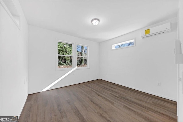 spare room featuring dark hardwood / wood-style floors and a wall mounted AC