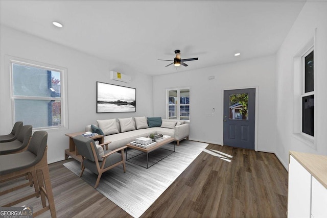 living room featuring dark hardwood / wood-style floors, ceiling fan, plenty of natural light, and a wall unit AC