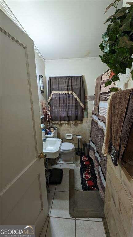 bathroom featuring a sink, toilet, and tile patterned flooring