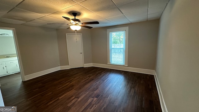 empty room featuring sink, ceiling fan, dark hardwood / wood-style floors, and a paneled ceiling