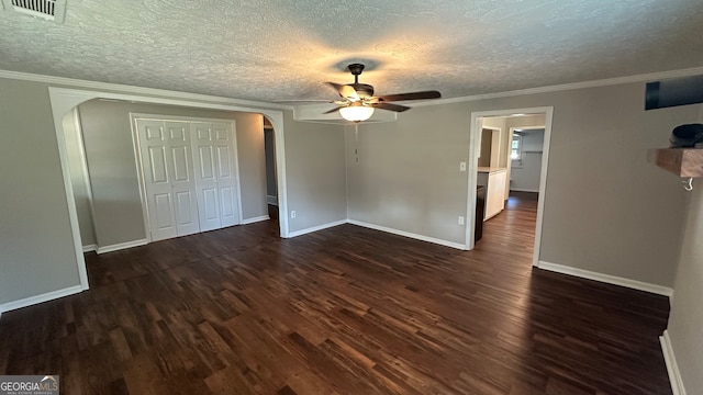 unfurnished room with ceiling fan, a textured ceiling, dark hardwood / wood-style floors, and ornamental molding