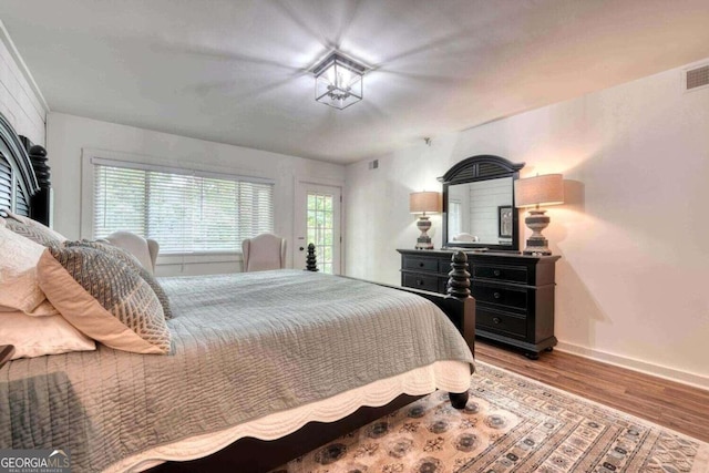 bedroom featuring visible vents, baseboards, and wood finished floors
