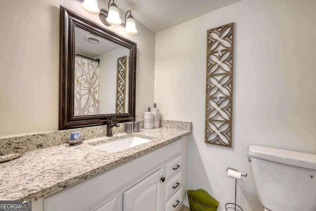 bathroom featuring visible vents, toilet, and vanity