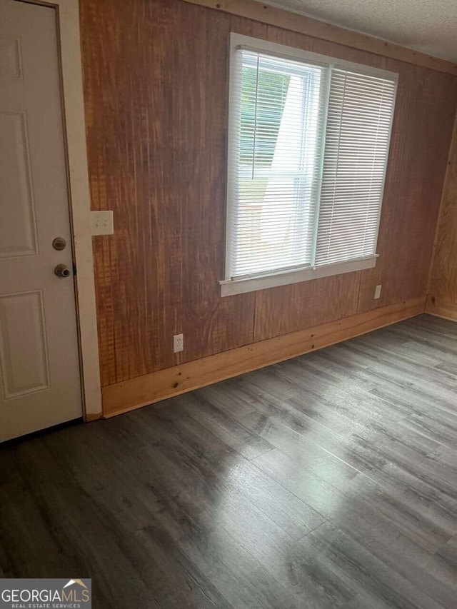 spare room with wooden walls and hardwood / wood-style flooring