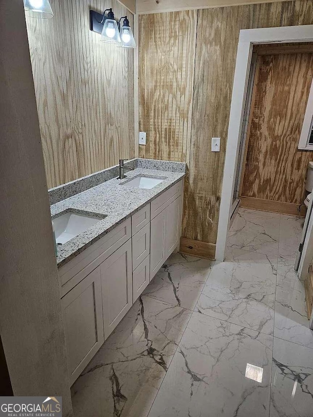 bathroom featuring vanity and wooden walls