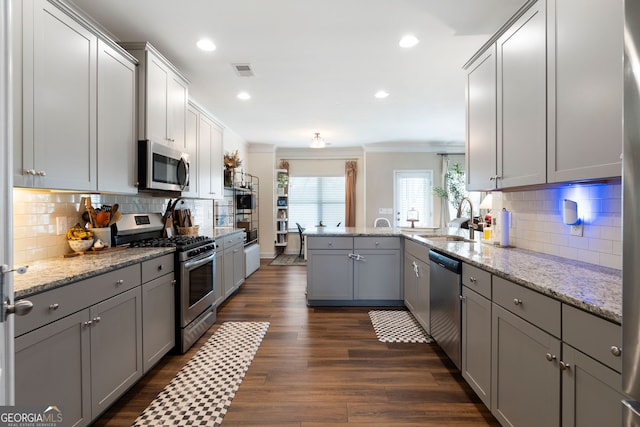 kitchen featuring gray cabinets, dark hardwood / wood-style floors, sink, appliances with stainless steel finishes, and ornamental molding