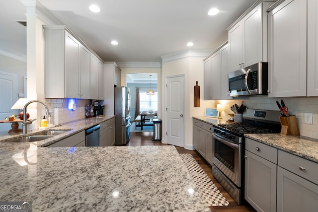 kitchen with light stone counters, stainless steel appliances, crown molding, dark hardwood / wood-style floors, and sink