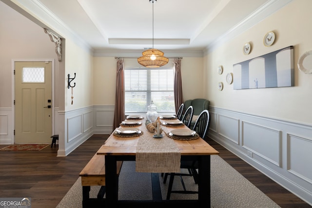 dining space with a raised ceiling, crown molding, and dark hardwood / wood-style flooring