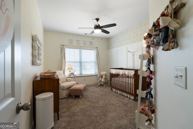 bedroom with ceiling fan, a crib, and carpet floors