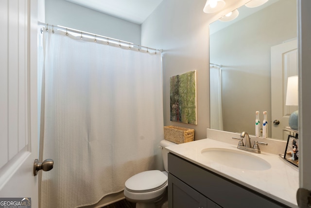 bathroom featuring curtained shower, vanity, and toilet