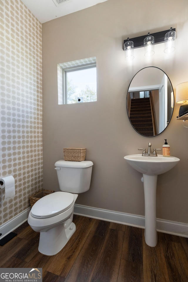 bathroom featuring wood-type flooring and toilet