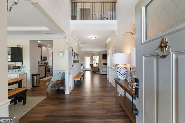 foyer with ornamental molding and dark wood-type flooring