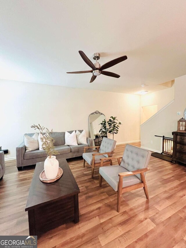 living room featuring light hardwood / wood-style floors and ceiling fan