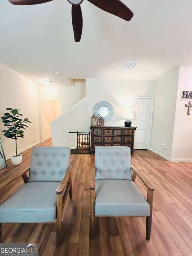 sitting room with ceiling fan and hardwood / wood-style floors