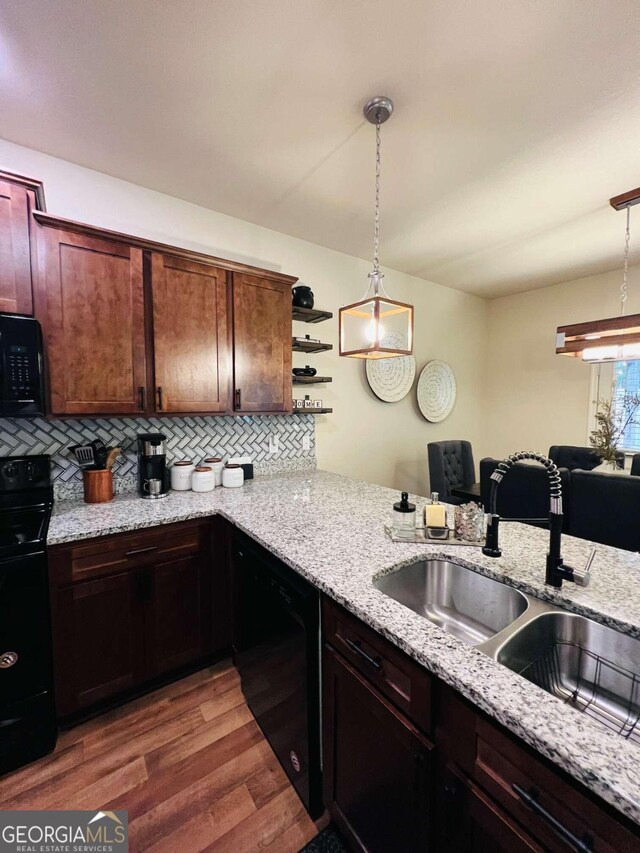 kitchen featuring black appliances, decorative backsplash, dark hardwood / wood-style floors, and decorative light fixtures