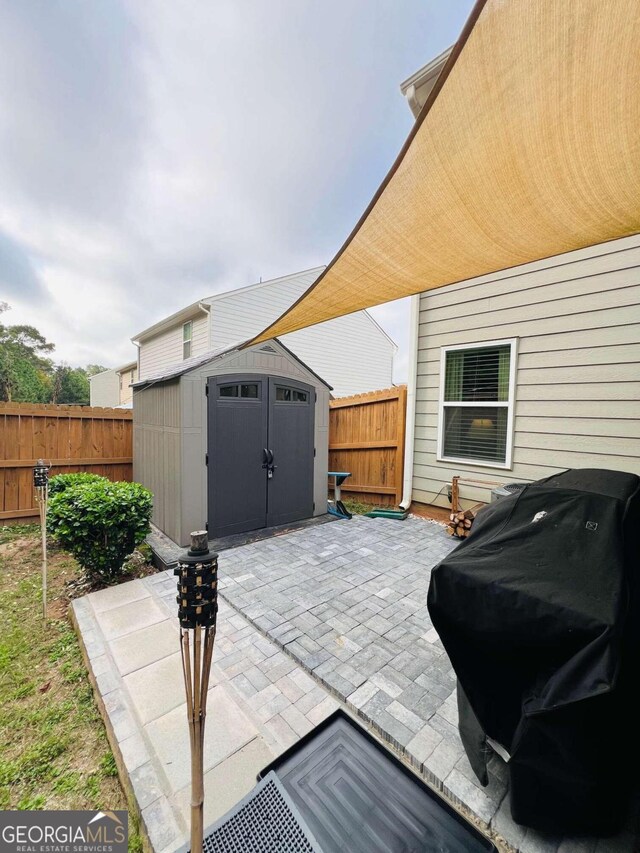 view of patio featuring grilling area and a storage shed