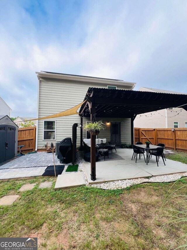 rear view of house featuring a storage shed, a pergola, a patio, and a lawn