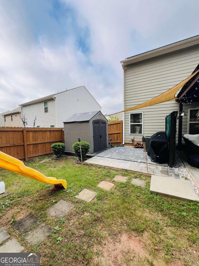 view of yard featuring a storage unit and a patio area