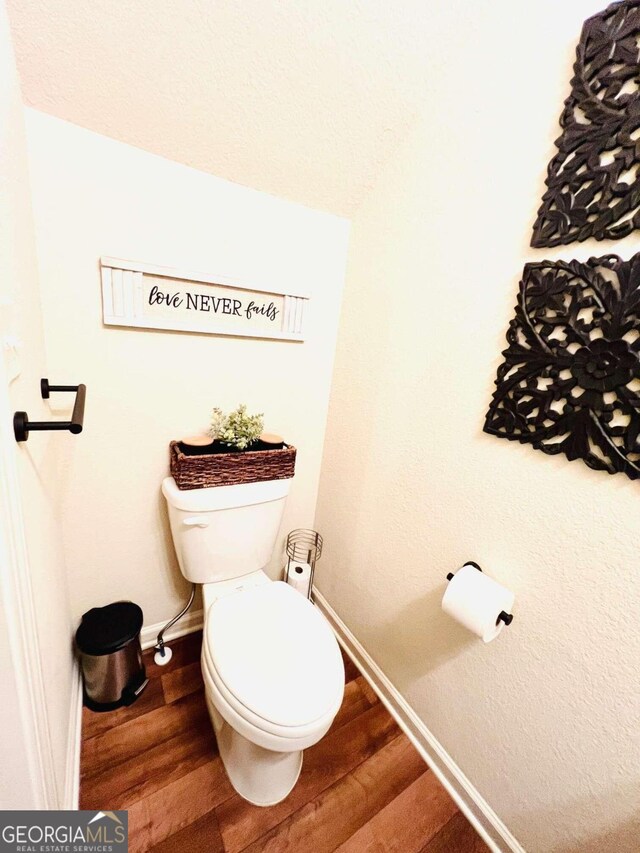 bathroom featuring hardwood / wood-style flooring and toilet