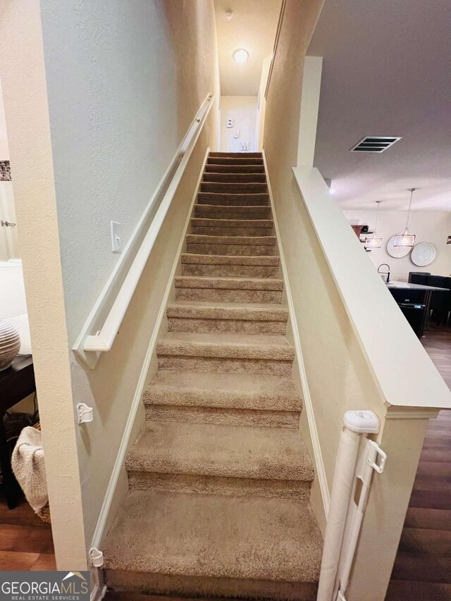 stairway with hardwood / wood-style floors