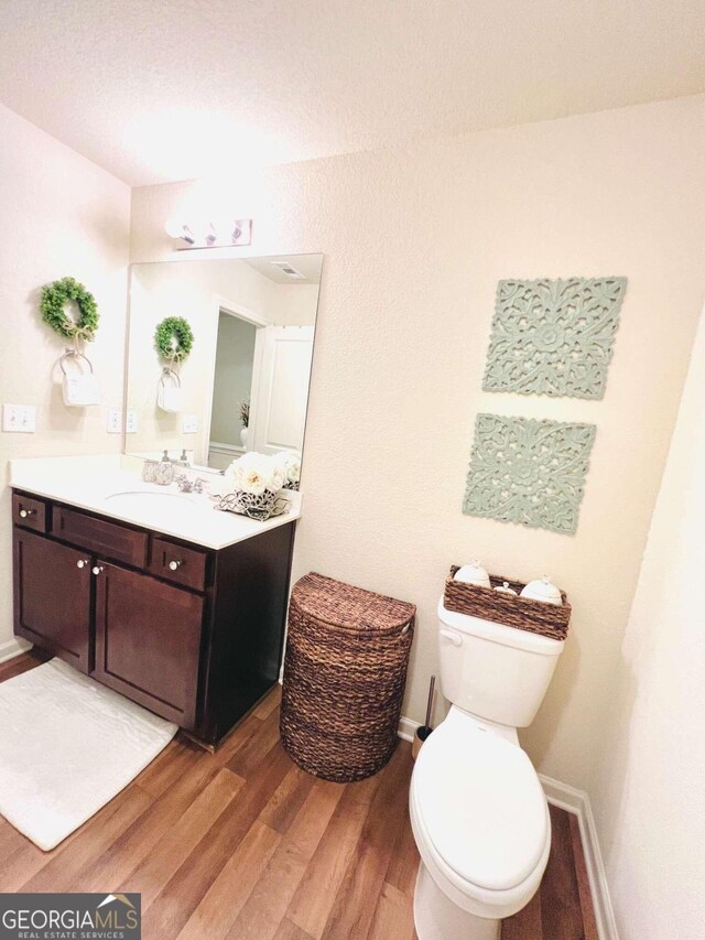 bathroom featuring hardwood / wood-style flooring, vanity, and toilet