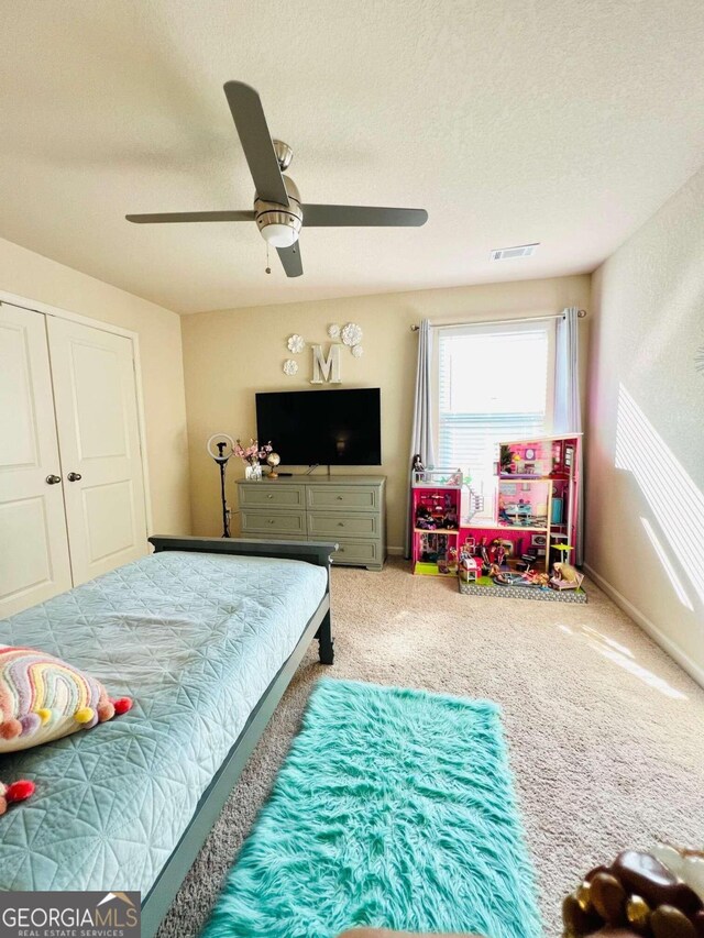 bedroom featuring carpet floors, a textured ceiling, ceiling fan, and a closet