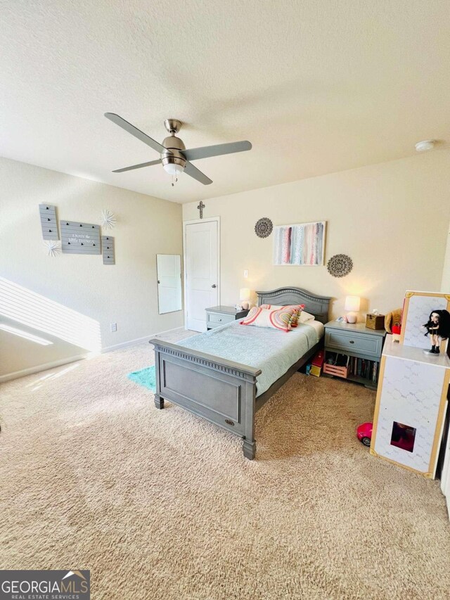 carpeted bedroom with a textured ceiling and ceiling fan