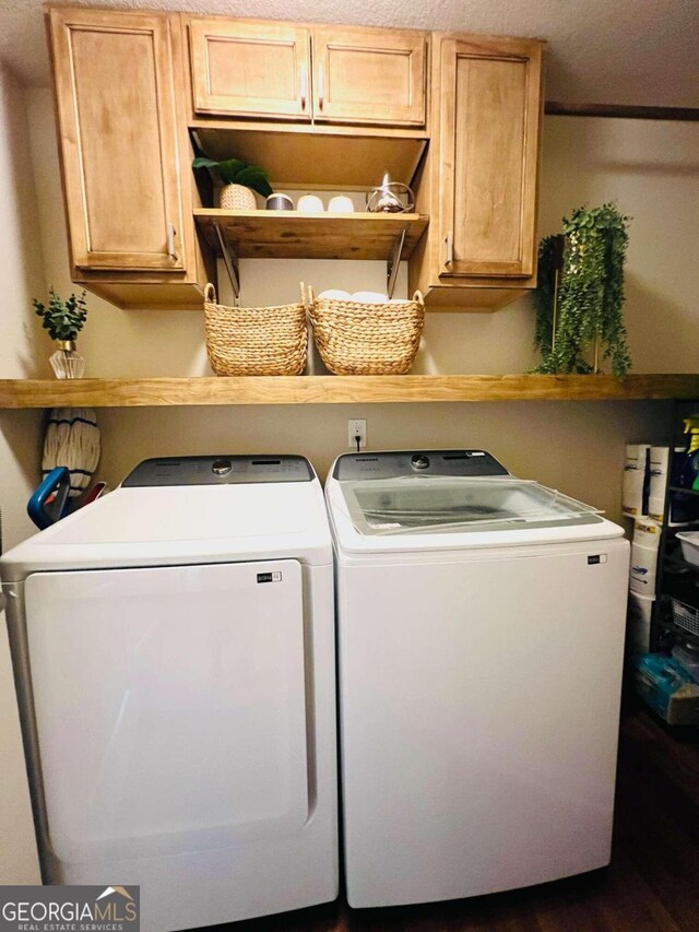 clothes washing area featuring cabinets, independent washer and dryer, and a textured ceiling