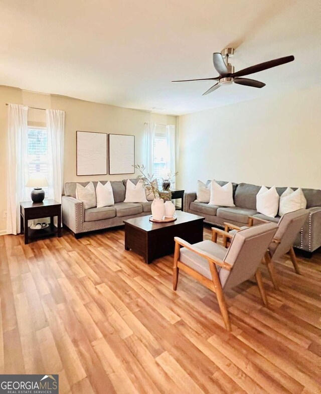 living room with light hardwood / wood-style flooring and ceiling fan