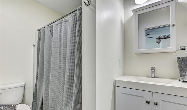 bathroom with vanity, toilet, and curtained shower