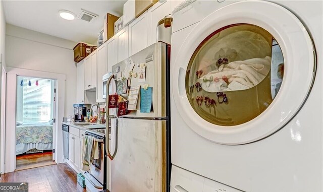 1313 Whitaker St, Savannah, GA 31401 - clothes washing area featuring wood finished floors and stacked washer / dryer