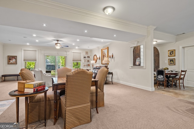 carpeted dining space featuring ornamental molding and ceiling fan