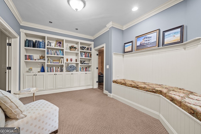 sitting room with ornamental molding and light carpet