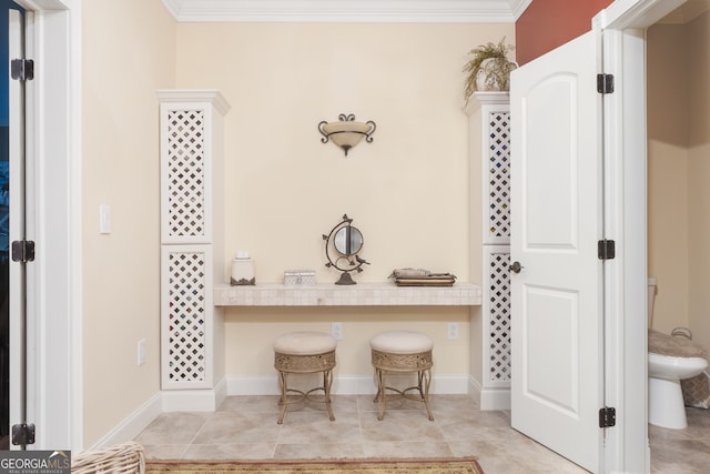 bathroom with toilet, crown molding, and tile patterned floors