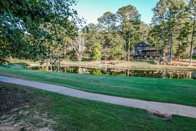 surrounding community featuring a water view and a lawn