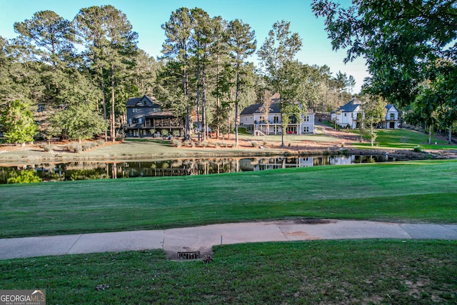 view of community featuring a lawn and a water view