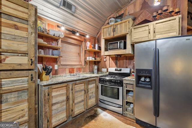 kitchen featuring appliances with stainless steel finishes, wooden walls, sink, wooden ceiling, and lofted ceiling