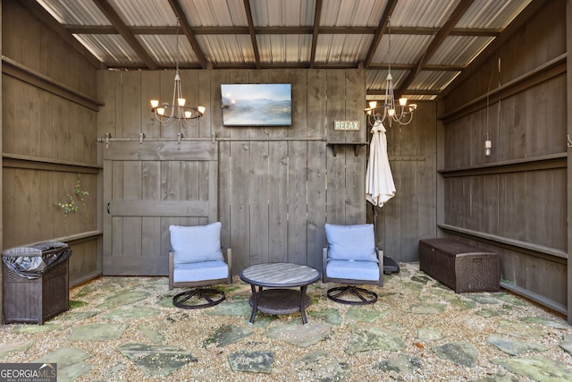 sitting room featuring wooden walls and a notable chandelier