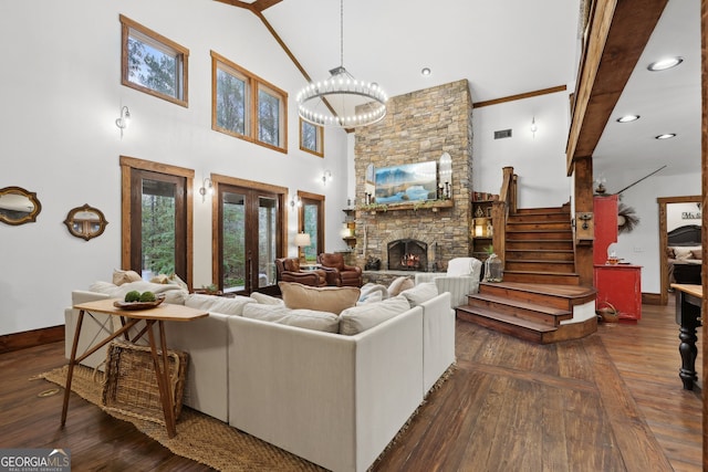 living room with dark hardwood / wood-style floors, beam ceiling, a fireplace, and an inviting chandelier