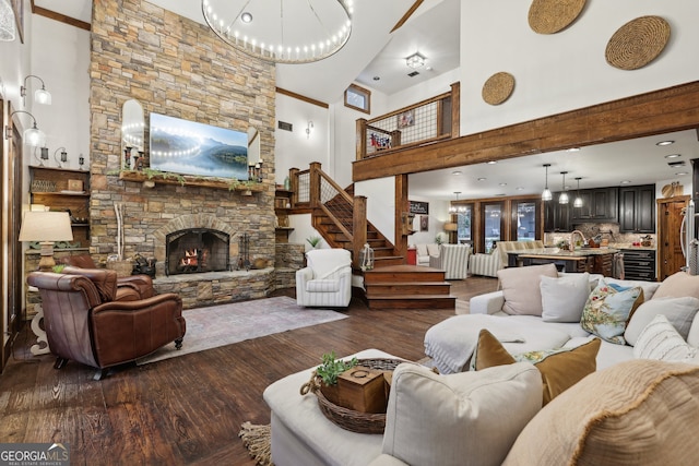 living room with a fireplace, a high ceiling, dark hardwood / wood-style flooring, and sink