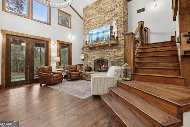 living room featuring a fireplace, wood-type flooring, high vaulted ceiling, and french doors