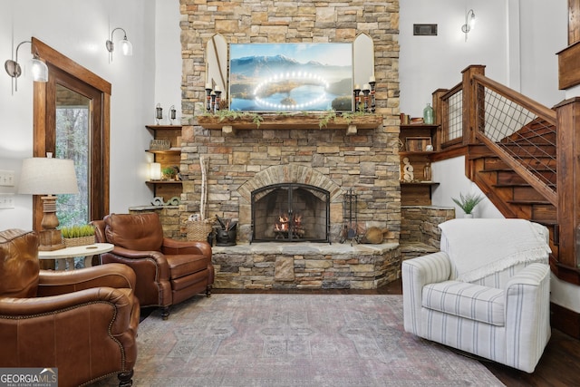 living room featuring a stone fireplace and a towering ceiling