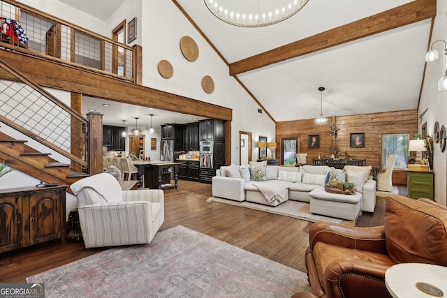 living room with beamed ceiling, dark hardwood / wood-style flooring, high vaulted ceiling, and wooden walls