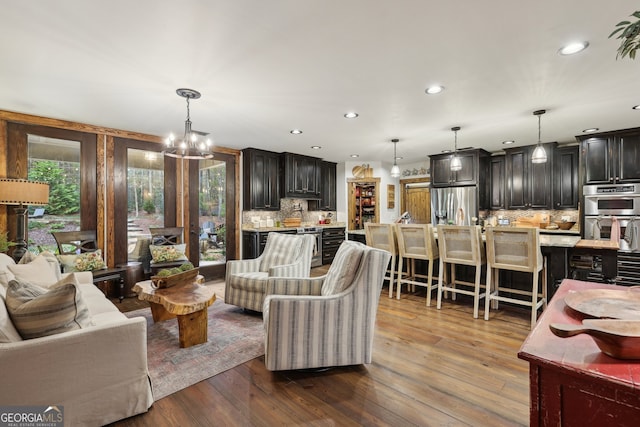 living room with light hardwood / wood-style floors and a notable chandelier