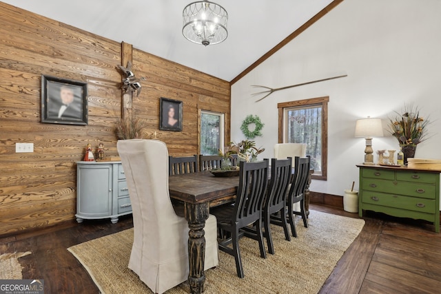 dining space with a notable chandelier, dark hardwood / wood-style flooring, crown molding, and high vaulted ceiling