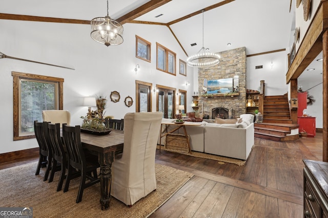 dining area with an inviting chandelier, beamed ceiling, high vaulted ceiling, dark hardwood / wood-style floors, and a fireplace