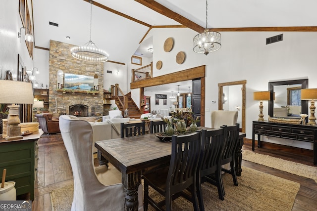 dining room with a stone fireplace, beamed ceiling, high vaulted ceiling, and wood-type flooring